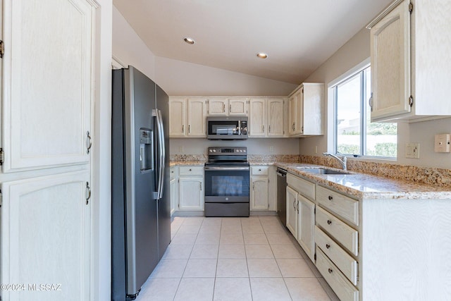 kitchen featuring sink, vaulted ceiling, light tile patterned floors, stainless steel appliances, and light stone countertops