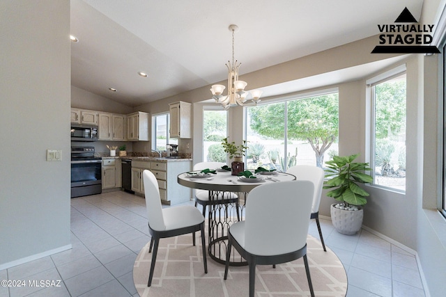 tiled dining area with an inviting chandelier, sink, and lofted ceiling