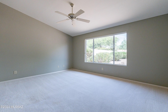 carpeted empty room featuring vaulted ceiling and ceiling fan