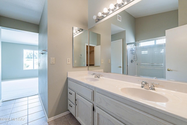 bathroom with tile patterned flooring, vanity, and an enclosed shower