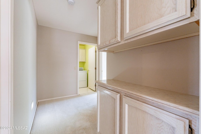 corridor with washer / dryer and light carpet