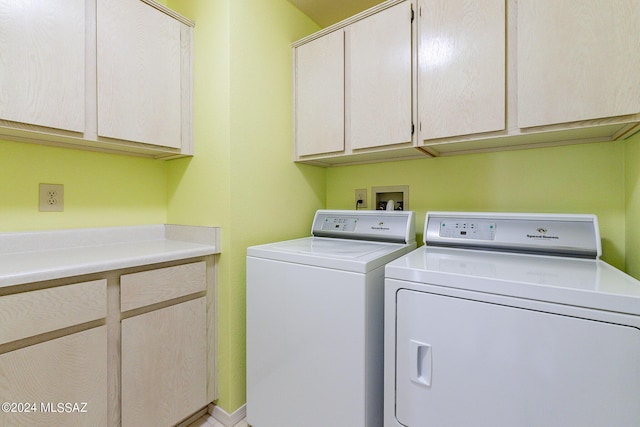 washroom featuring cabinets and washer and clothes dryer