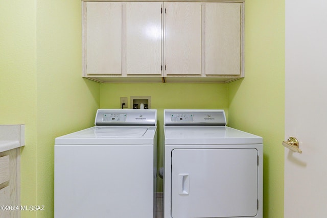 washroom with cabinets and washer and clothes dryer