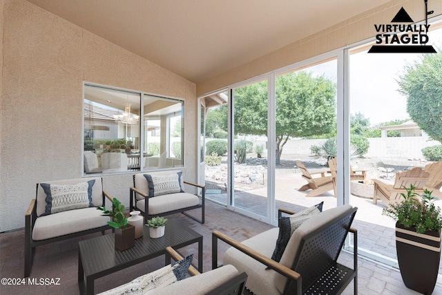 sunroom / solarium with vaulted ceiling and a chandelier