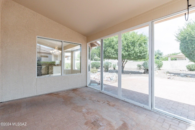 unfurnished sunroom with lofted ceiling and a notable chandelier