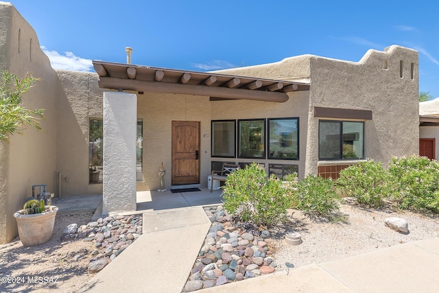 view of exterior entry with a patio area