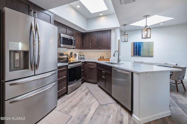 kitchen featuring light hardwood / wood-style floors, sink, a skylight, and stainless steel appliances