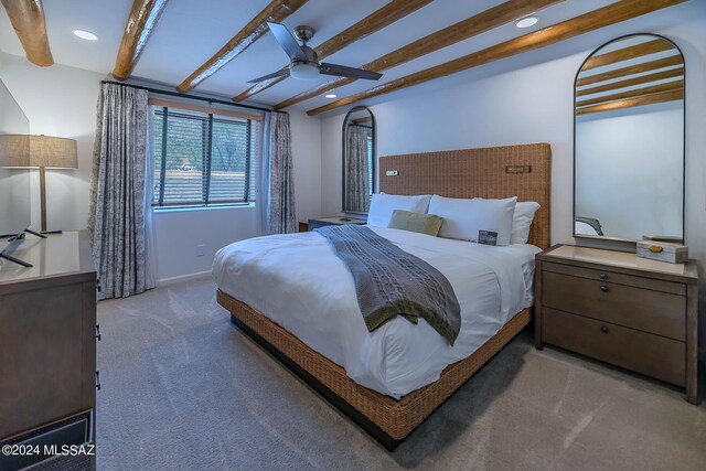 bedroom with carpet floors, beamed ceiling, and ceiling fan