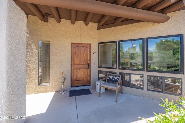 view of exterior entry featuring a patio area