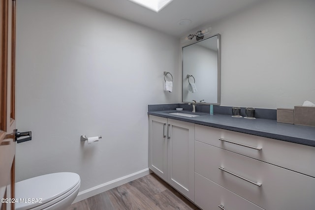 bathroom with vanity, toilet, and wood-type flooring