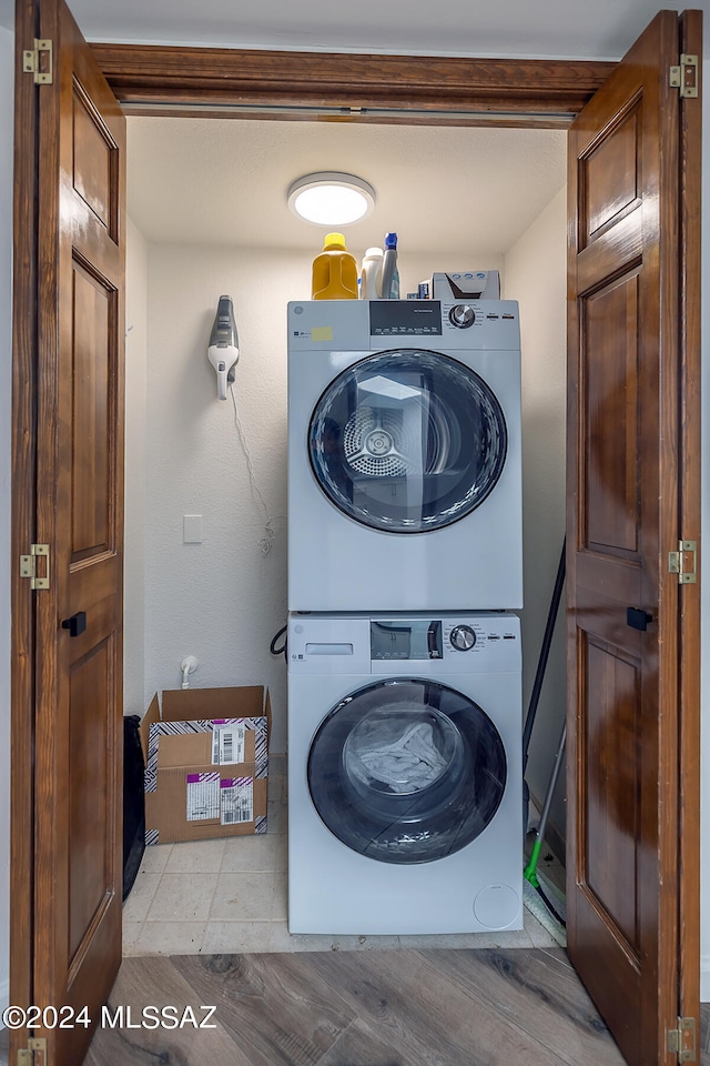 washroom featuring light hardwood / wood-style floors and stacked washer / drying machine