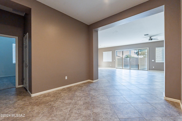 tiled empty room featuring ceiling fan