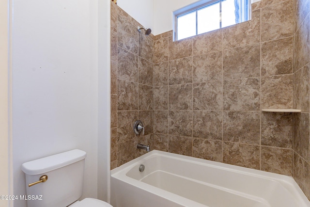 bathroom featuring tiled shower / bath combo and toilet