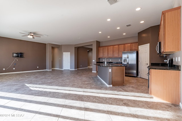 kitchen featuring stainless steel appliances, a center island with sink, sink, and ceiling fan