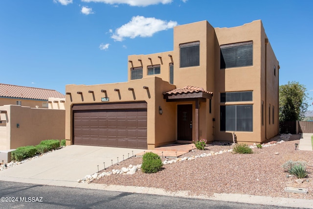 pueblo revival-style home with a garage