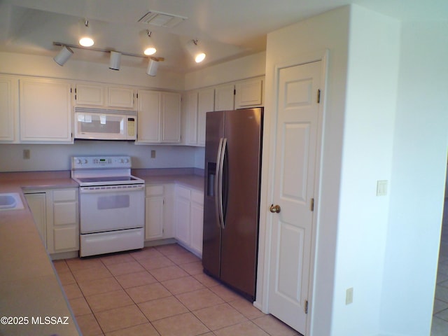 kitchen featuring white cabinetry, light tile patterned floors, and white appliances