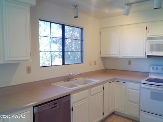 kitchen with sink, white appliances, light tile patterned floors, and white cabinets