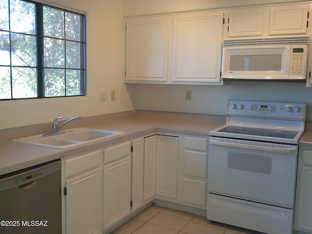 kitchen with white cabinetry, white appliances, sink, and light tile patterned floors