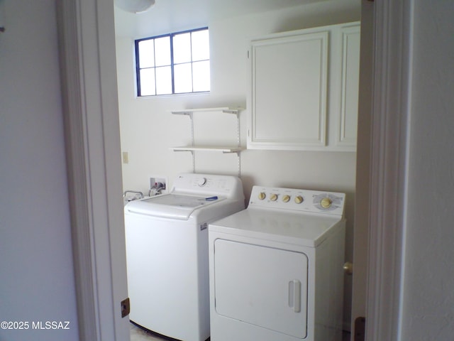 clothes washing area featuring cabinets and washer and dryer