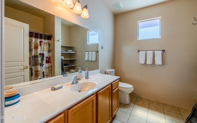 bathroom featuring vanity, toilet, tile patterned floors, and a wealth of natural light