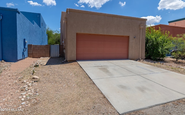 adobe home featuring an outdoor structure and a garage