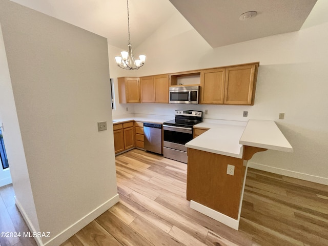 kitchen featuring light wood-type flooring, kitchen peninsula, appliances with stainless steel finishes, and decorative light fixtures