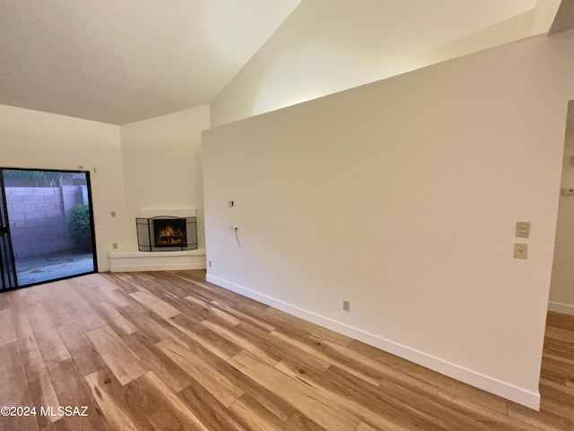 unfurnished living room featuring lofted ceiling and hardwood / wood-style floors