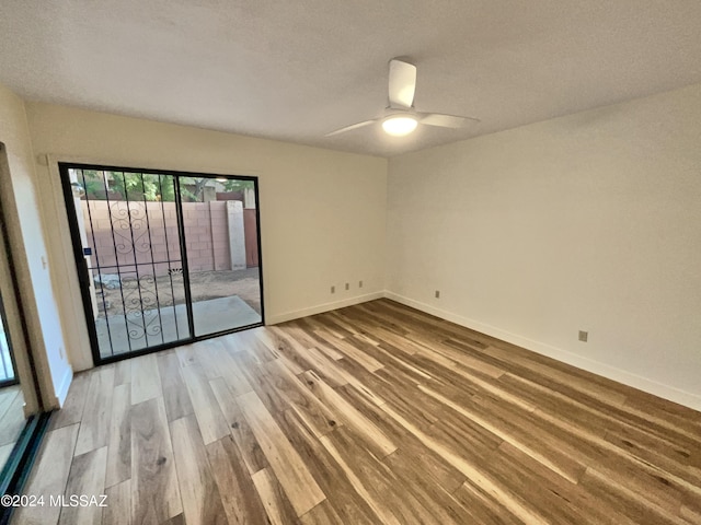 empty room with ceiling fan, hardwood / wood-style flooring, and a textured ceiling