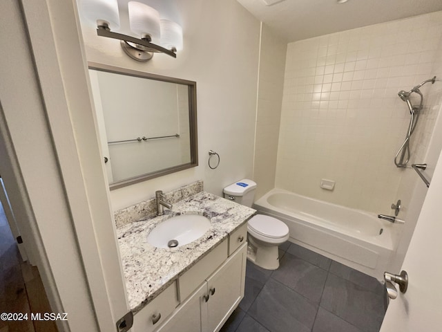 full bathroom featuring tile patterned floors, tiled shower / bath combo, vanity, and toilet