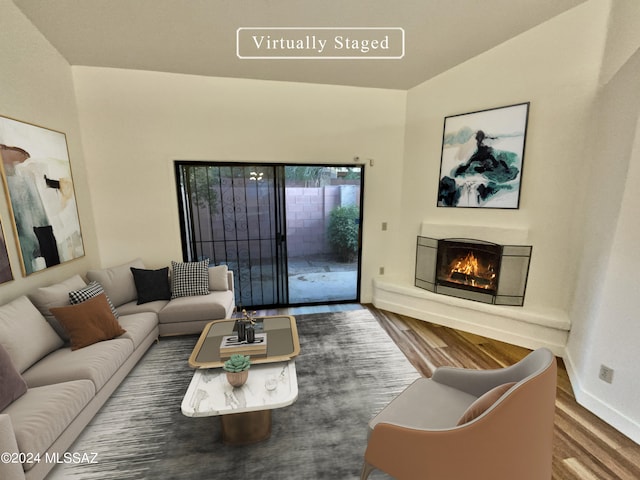 living room featuring wood-type flooring and vaulted ceiling