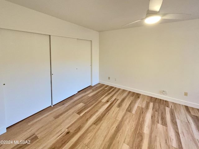 unfurnished bedroom with ceiling fan, light wood-type flooring, and a closet