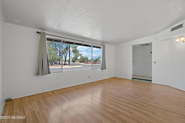 spare room featuring visible vents and wood finished floors