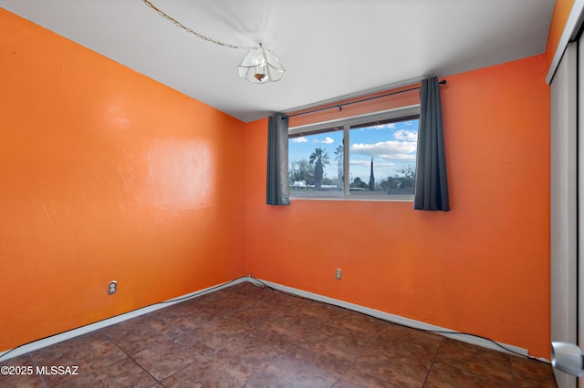 unfurnished room with baseboards