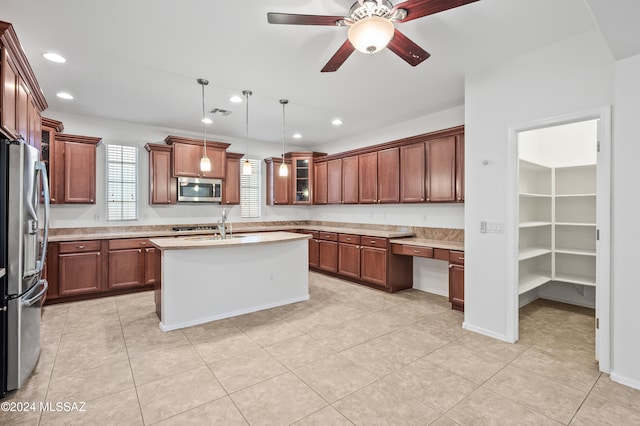 kitchen with pendant lighting, a center island with sink, ceiling fan, light tile patterned floors, and appliances with stainless steel finishes