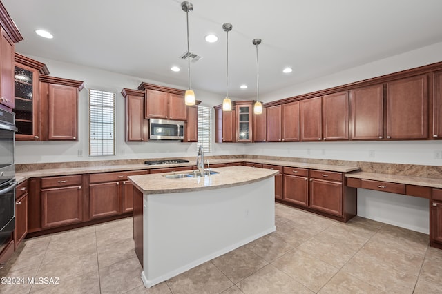 kitchen featuring sink, pendant lighting, a kitchen island with sink, built in desk, and appliances with stainless steel finishes