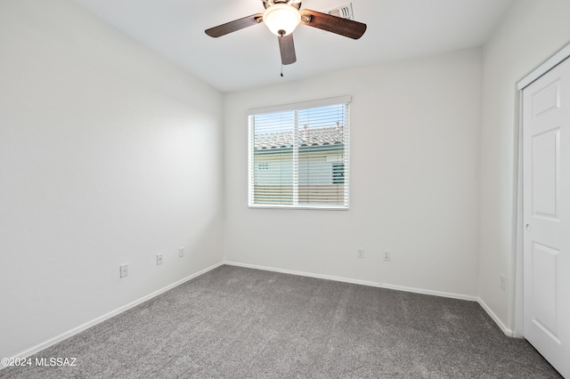 unfurnished bedroom featuring dark colored carpet and ceiling fan