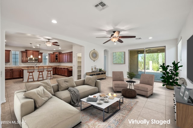 living room with ceiling fan and light tile patterned flooring