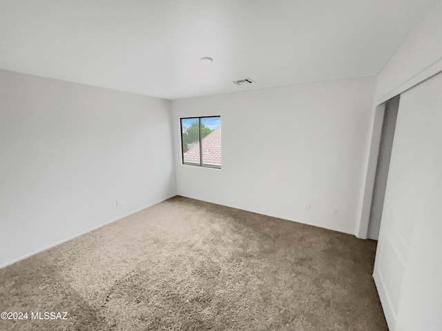 unfurnished room with dark colored carpet