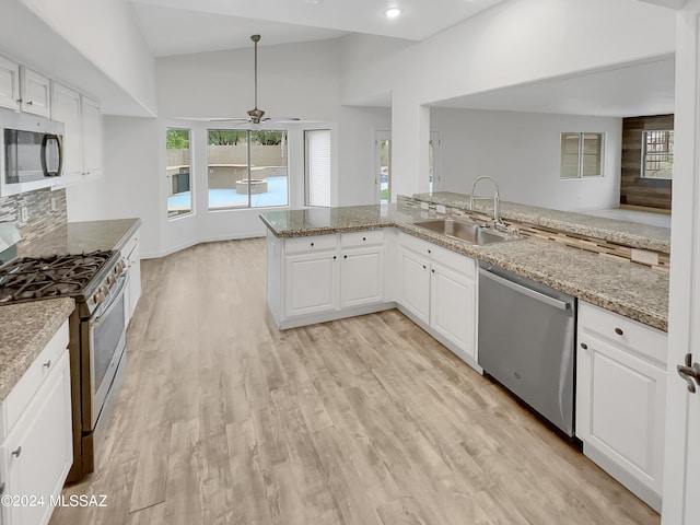 kitchen featuring stainless steel appliances, sink, light hardwood / wood-style floors, white cabinetry, and ceiling fan