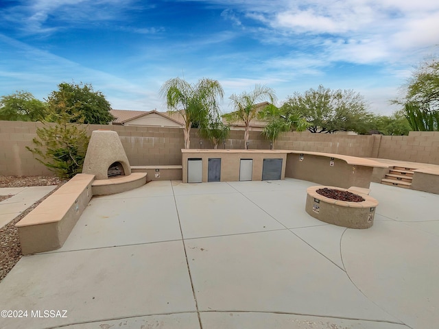 view of patio / terrace with an outdoor kitchen, an outdoor fireplace, and an outdoor fire pit