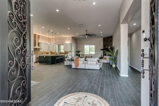 living room featuring a stone fireplace, hardwood / wood-style floors, and ceiling fan