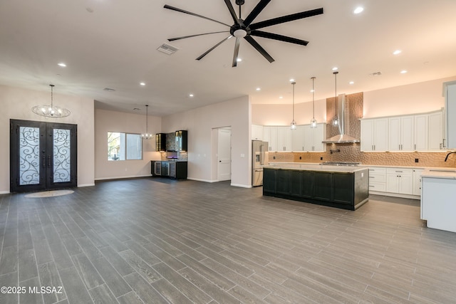 2102 N Corte El Rancho Merlita, Tucson, AZ 85715 - kitchen with wall chimney exhaust hood, stainless steel appliances, french doors, open floor plan, and light countertops