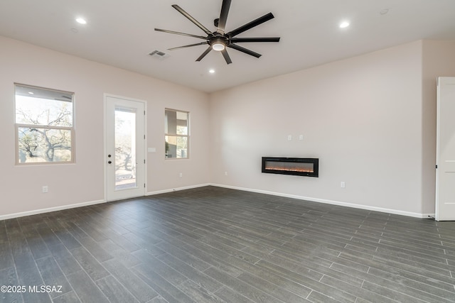 2102 N Corte El Rancho Merlita, Tucson, AZ 85715 - unfurnished living room with a ceiling fan, dark wood finished floors, a glass covered fireplace, and recessed lighting