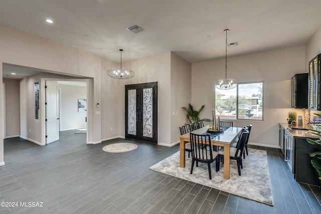 dining space featuring an inviting chandelier, dark hardwood / wood-style floors, and french doors