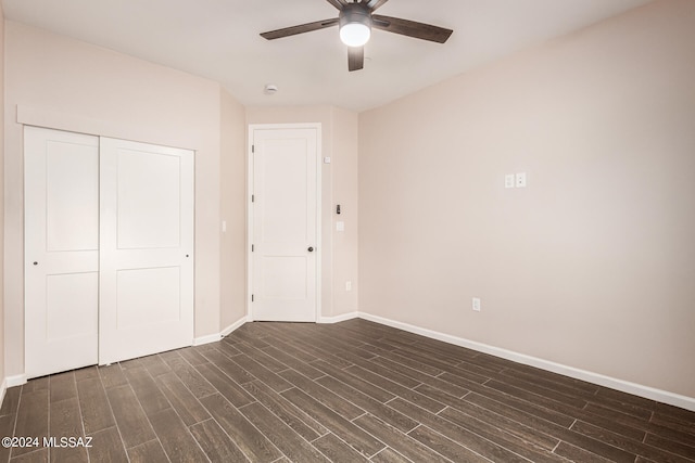 unfurnished bedroom featuring dark hardwood / wood-style floors, ceiling fan, and a closet