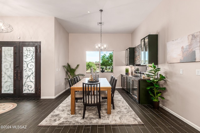 dining room featuring an inviting chandelier, sink, dark wood-type flooring, and french doors