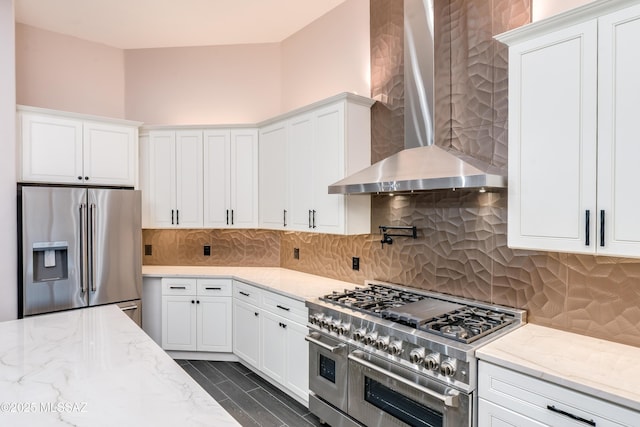 2102 N Corte El Rancho Merlita, Tucson, AZ 85715 - kitchen with stainless steel appliances, wall chimney exhaust hood, white cabinetry, and light stone counters