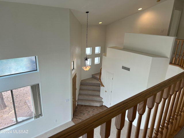 stairway featuring carpet and a towering ceiling