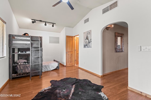 bedroom featuring arched walkways, visible vents, and wood finished floors