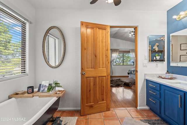 full bathroom featuring a ceiling fan, ensuite bath, tile patterned floors, a freestanding bath, and vanity